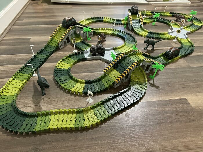 Children’s dinosaur-themed race track toy set with flexible green tracks and animal figures, featured in Black Friday deals on kids toys.
