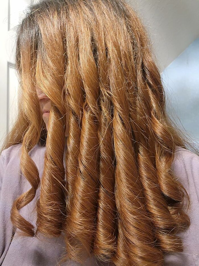 Woman with long, shiny red hair styled in defined curls, showcasing a 11.11 deals lucky hair transformation.