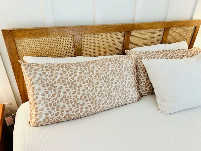 Wooden headboard with woven panels on a bed featuring leopard print pillows, perfect foolproof gift finds idea.