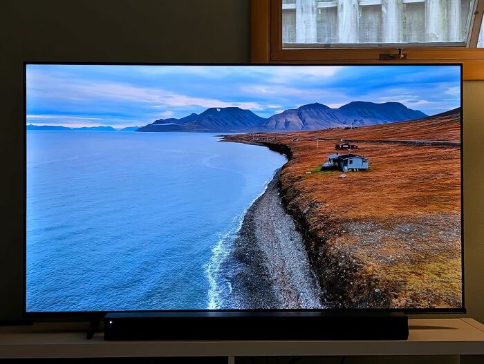 Television screen showing a coastal landscape with mountains and ocean, highlighting Cyber Monday weekend deals.