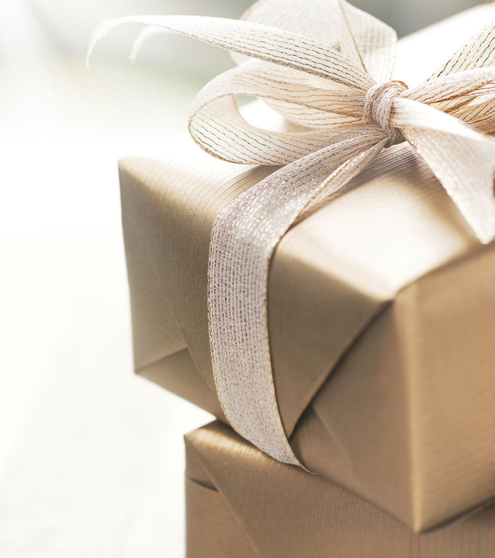 Wrapped expensive Christmas gifts with white ribbon, symbolizing woman buying presents for boyfriend&rsquo;s kids.