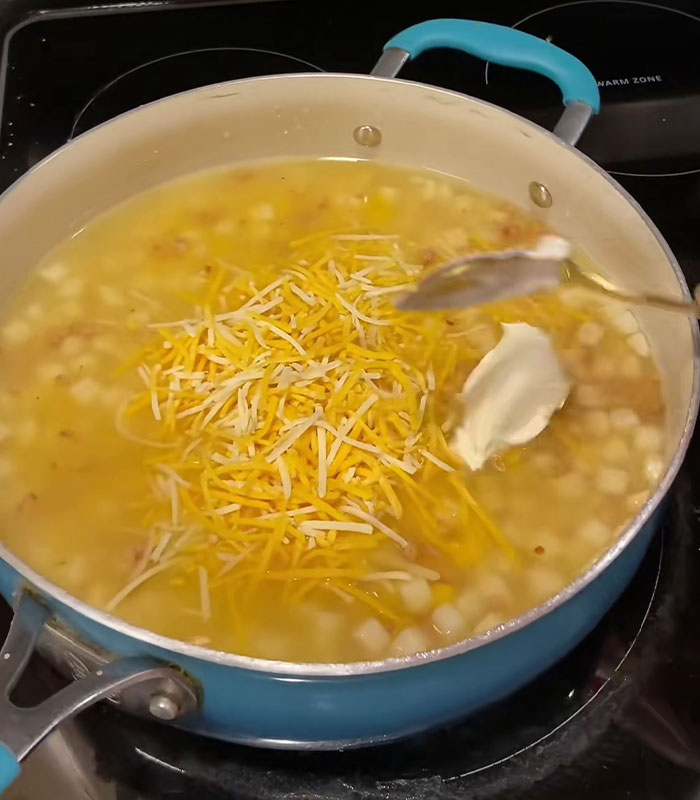 Blue pot on stove with wild American food creation of shredded cheese and sour cream mixed in soup. Blue pot on stove with wild American food creation of shredded cheese and sour cream mixed in soup.