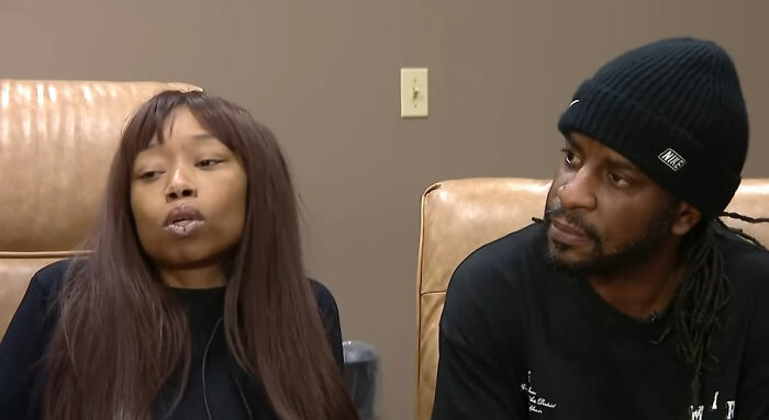 Two people sitting on a couch, discussing an incident involving a pregnant woman attacked by a mob of young school kids.