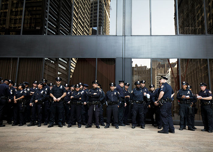 Group of police officers standing in front of a glass building, relating to trainee police officer lifetime ban news. Group of police officers standing in front of a glass building, relating to trainee police officer lifetime ban news.