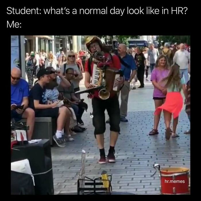 Street performer playing multiple instruments at once while people watch, illustrating chaos of working in HR.