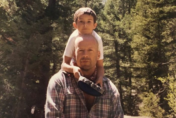 Bruce Willis with young child outdoors, capturing a family moment amid nature, relating to update on his dementia.