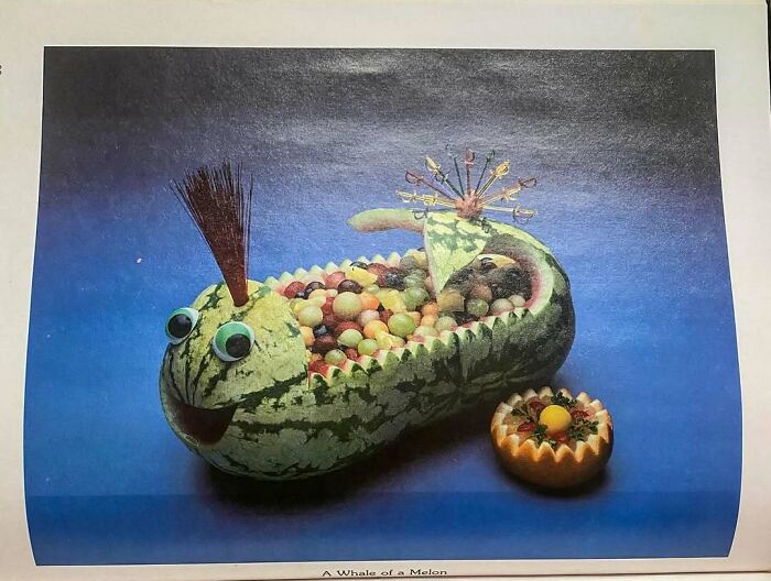 Creative vintage recipe featuring a watermelon shaped like a whale filled with fruit salad on blue background.