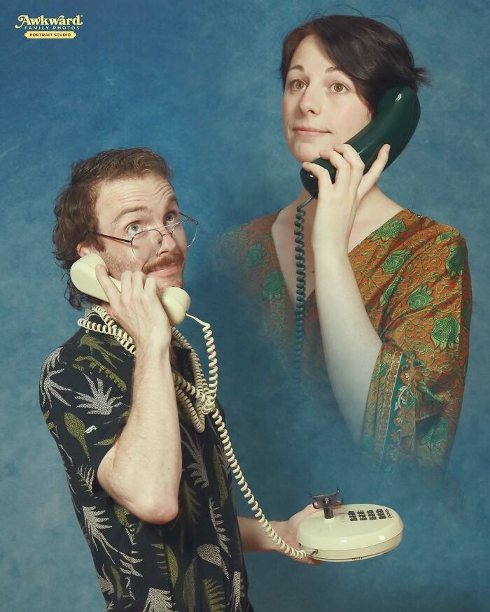 Man and woman in an awkward studio photo, each holding vintage telephones with humorous expressions.