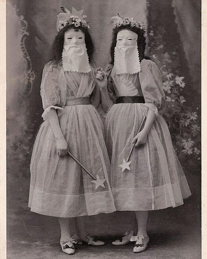 Two Victorian-era women in unusual masks and dresses holding star-tipped wands, showcasing weird photos from the Victorian era.