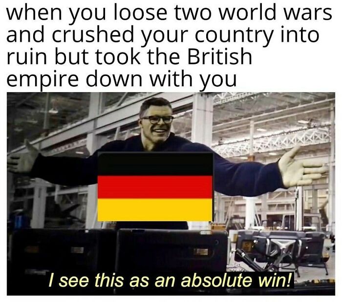Man with German flag edited on chest in a warehouse, caption highlighting history memes about world wars and British empire.