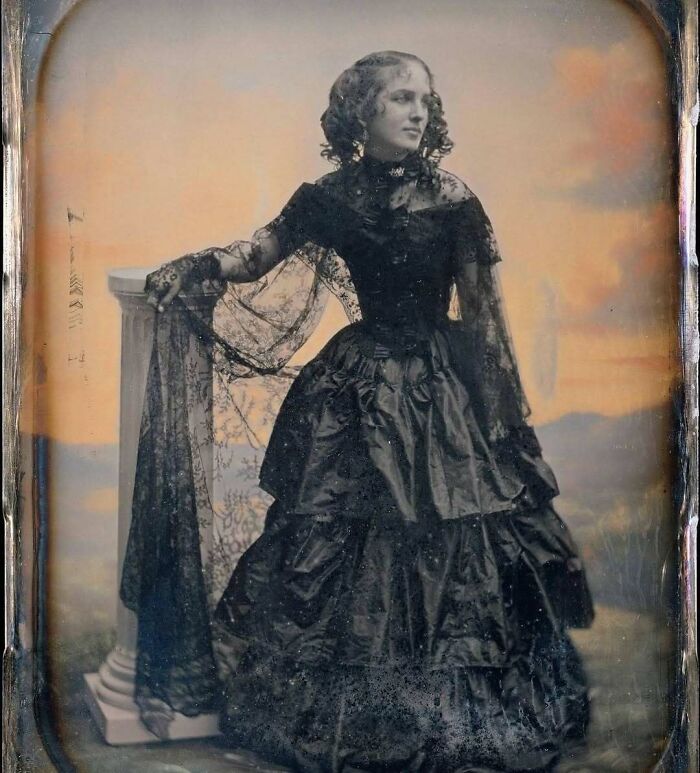 Victorian era woman posing in elaborate dark dress with lace details, showcasing fashion from the weird Victorian era photos.