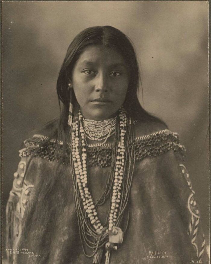 Victorian era portrait of a Native American woman wearing traditional beadwork and clothing in a weird photo from the past.