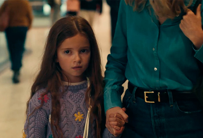 Young girl looking concerned while holding an adult’s hand, highlighting why parents shouldn’t post about their children online. Young girl looking concerned while holding an adult’s hand, highlighting why parents shouldn’t post about their children online.