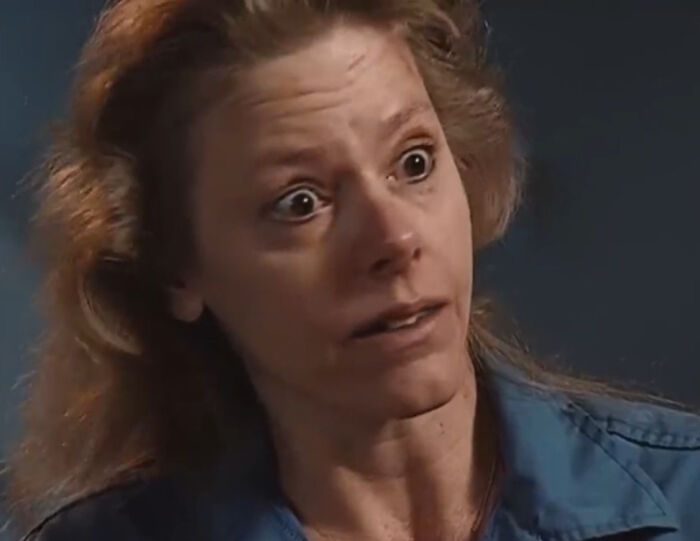 Close-up of a woman in a blue shirt with a shocked expression in a scene from a Netflix doc on a famous serial criminal. Close-up of a woman in a blue shirt with a shocked expression in a scene from a Netflix doc on a famous serial criminal.