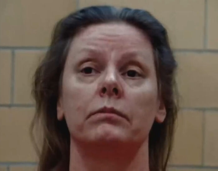 Close-up of a woman with a serious expression in a dimly lit room, relating to a Netflix doc about a famous serial criminal. Close-up of a woman with a serious expression in a dimly lit room, relating to a Netflix doc about a famous serial criminal.