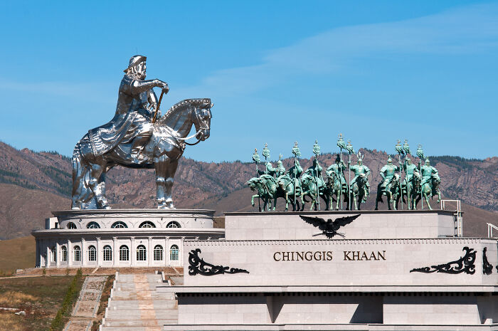 Massive spectacular sculpture of Chinggis Khaan on horseback with armored warriors in the background.
