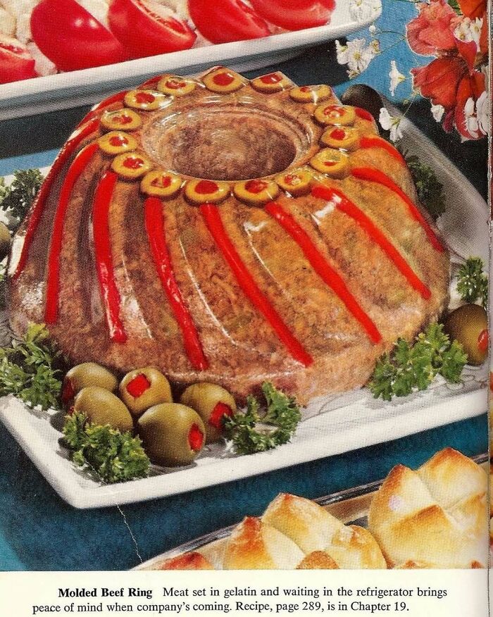 Vintage molded beef ring decorated with olives and red peppers, a disturbing creative vintage recipe from Gen X era.