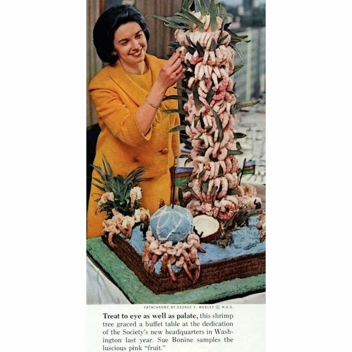 Woman in yellow dress arranging a vintage creative shrimp tree buffet display, showcasing disturbingly creative vintage recipes.