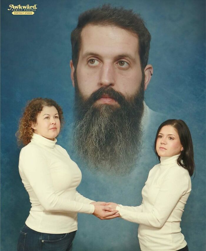 Two women holding hands with a large floating bearded man's portrait in the background in an awkward studio setting