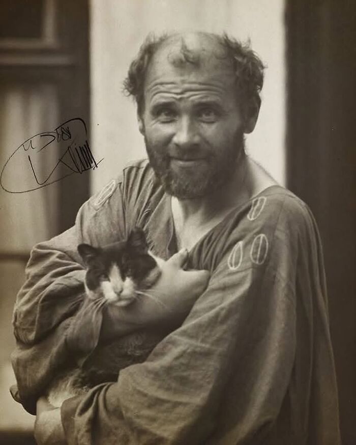 Victorian era man with unkempt hair and beard holding a cat, showcasing weird photos from the Victorian era.