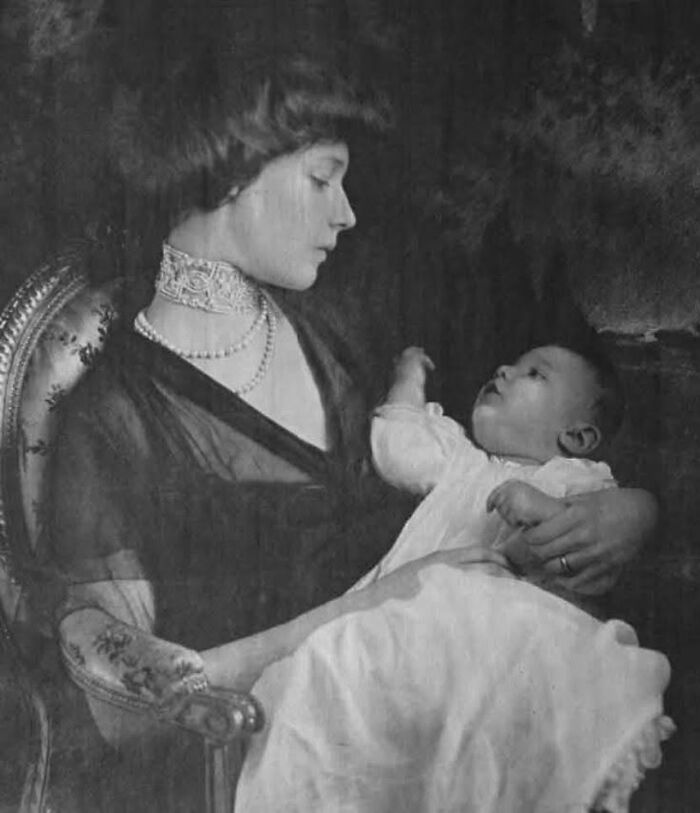 Victorian era mother in lace collar holding baby dressed in white, showcasing a weird photo from the Victorian era.