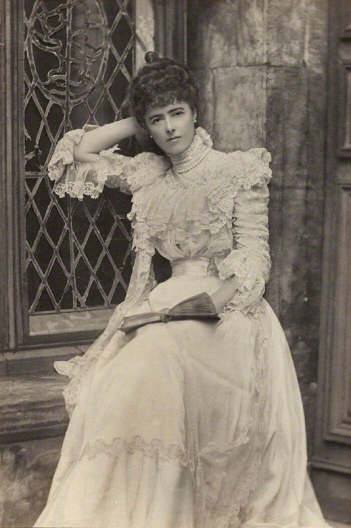 Vintage portrait of a woman in lace dress holding a book, representing overlooked women in history and their achievements.