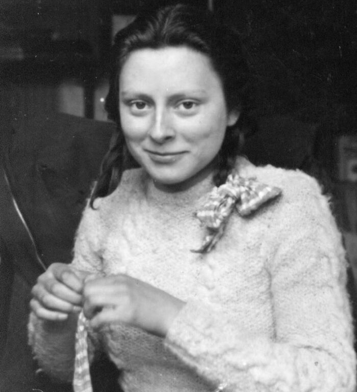 Black and white photo of a young woman knitting, representing overlooked women in history and their achievements.