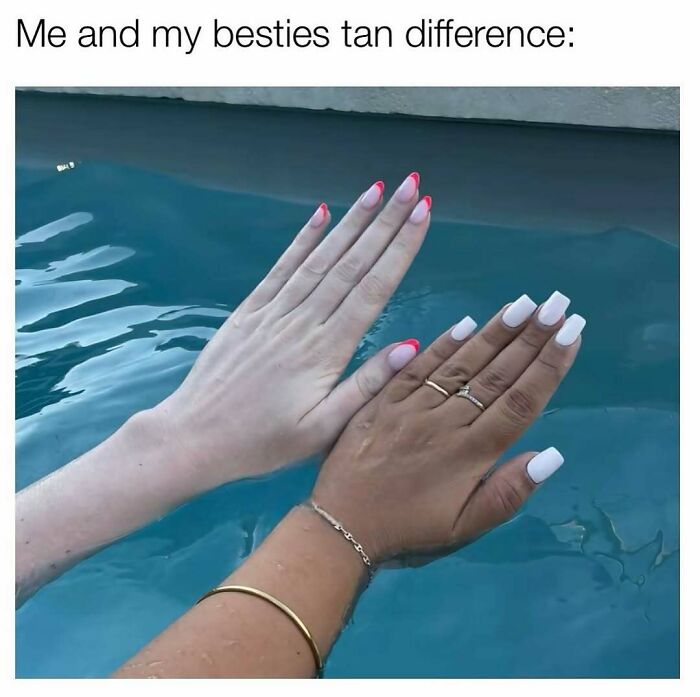 Two hands with contrasting tan shades above water, showcasing nails and jewelry, reflecting makeup and diva life style humor.