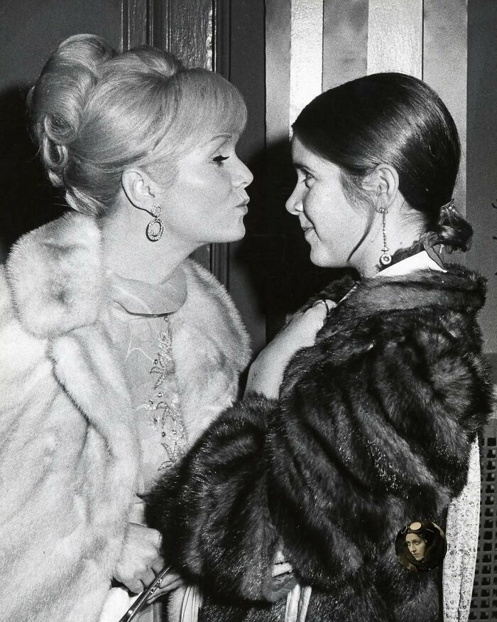Two women in vintage fur coats sharing a moment, representing overlooked women in history and their important achievements.