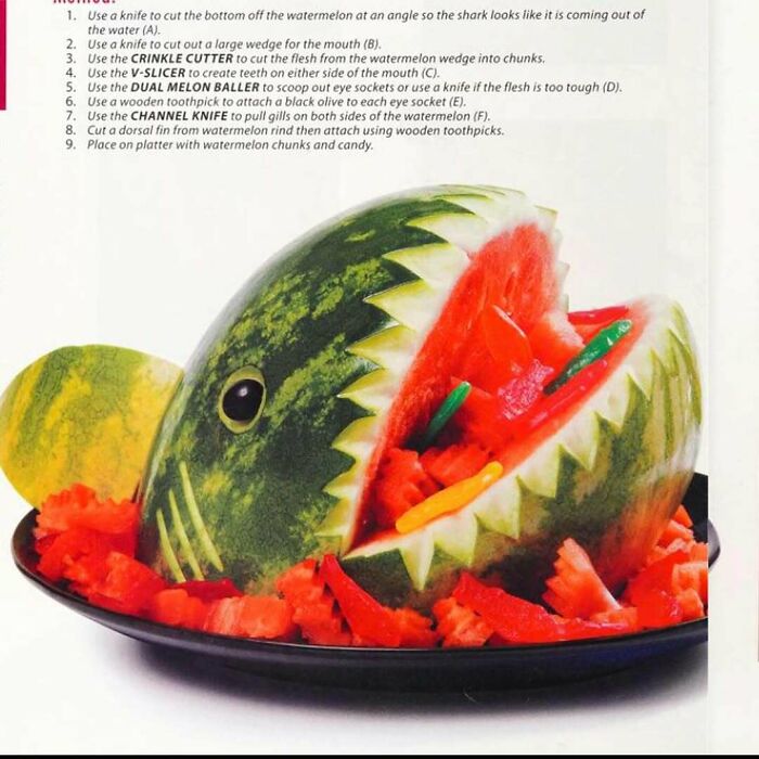 Creative vintage recipe carving a watermelon shark filled with fruit chunks on a black platter, showcasing Gen X food art.