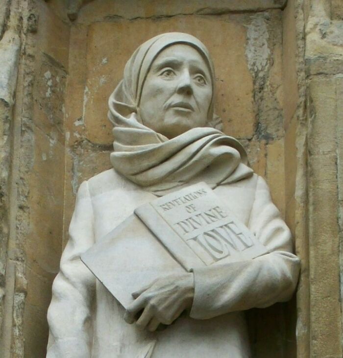 Marble statue of a woman wearing a headscarf holding a book, representing overlooked women in history and achievements.