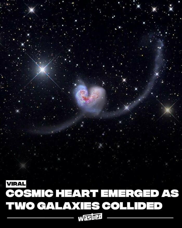 Cosmic heart formed by two galaxies colliding in space, with stars scattered across the dark sky background.