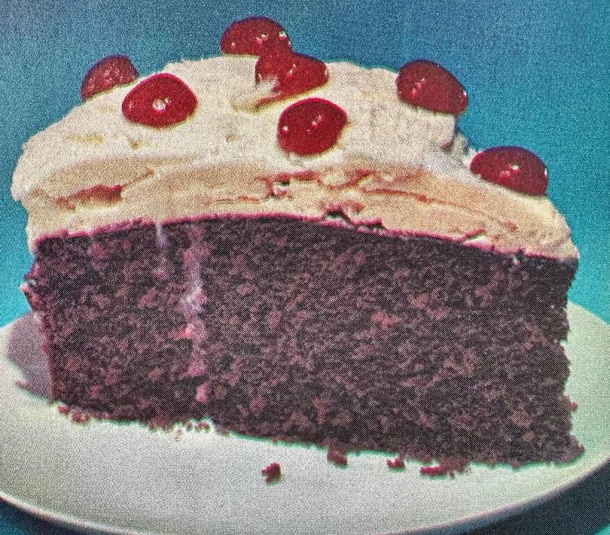Slice of vintage cake with frosting and cherries, showcasing interesting vintage recipes and bizarre dishes from the past
