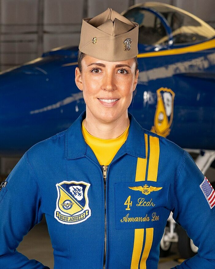 Female pilot in Blue Angels uniform standing confidently in front of fighter jet representing overlooked women in history achievements