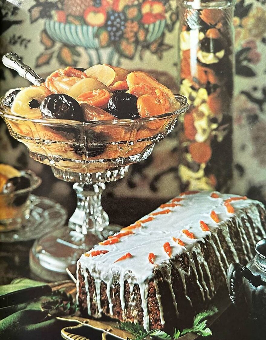 Vintage recipes dessert with glazed cake and mixed fruit salad in a glass bowl showcasing interesting vintage dishes.