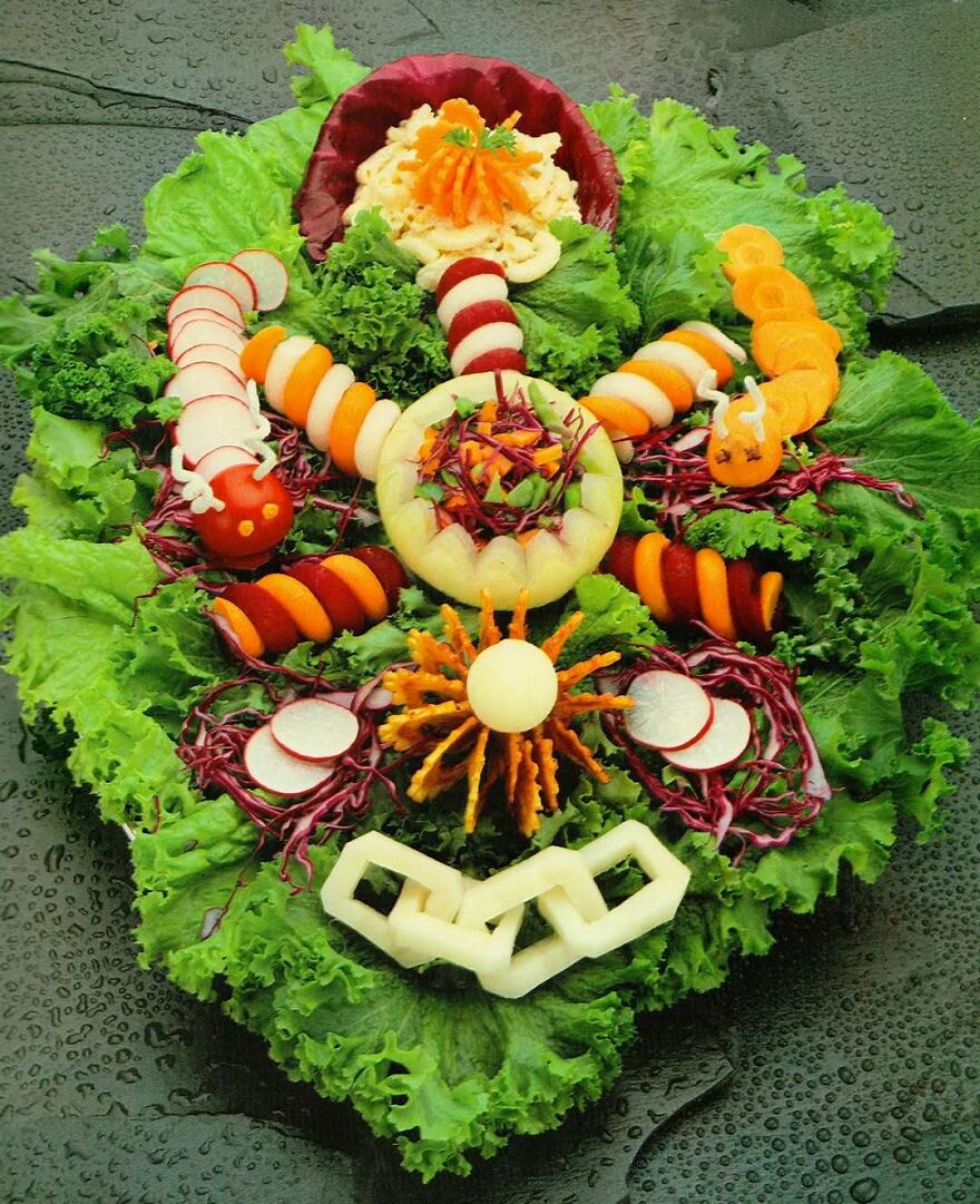 Vintage recipe vegetable platter artfully arranged with leafy greens, radishes, carrots, and other colorful produce in playful shapes