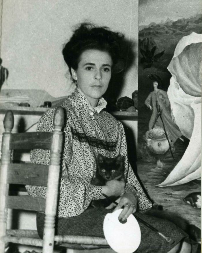 Black and white photo of a woman artist holding a cat, highlighting overlooked women in history and their achievements.