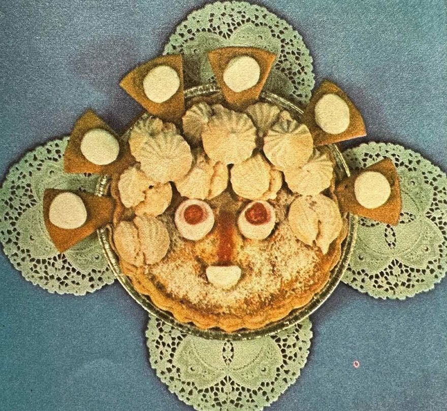 Vintage recipes dessert styled with cookies and pastries arranged to resemble a face on lace doilies and a blue background
