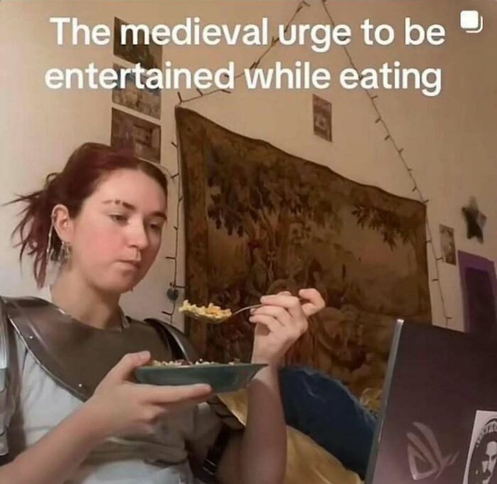 Person in medieval armor eating cereal while watching a laptop, illustrating humor in Laughgorithm meme collection.