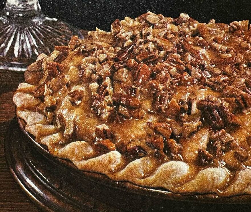 Close-up of a vintage pecan pie with a golden crust and nutty topping, showcasing interesting vintage recipes.