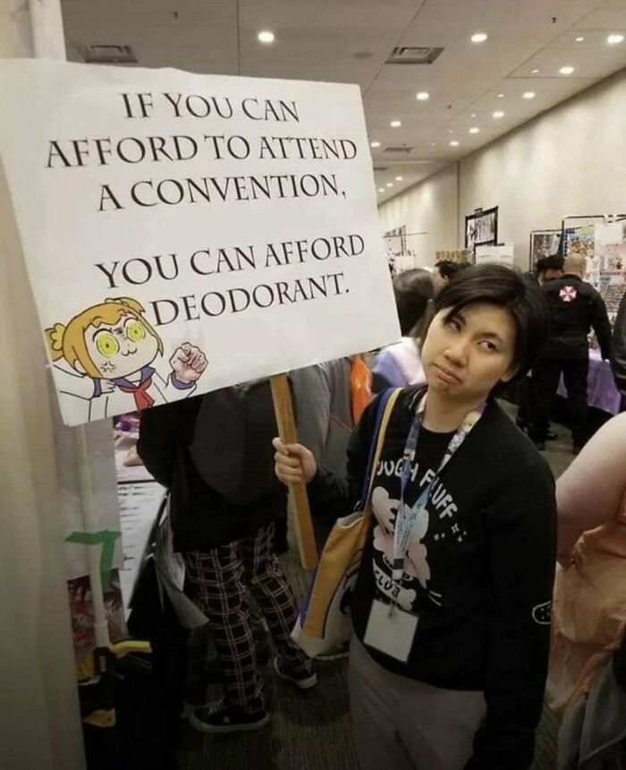 Person holding a humorous sign about conventions and deodorant, featured in a laughgorithm meme collection.