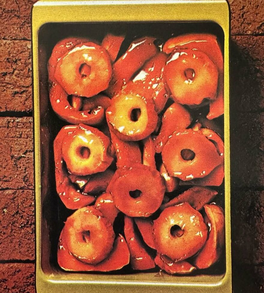 Vintage recipe dish with canned pineapple rings and cooked red bell peppers in a baking pan, showcasing bizarre vintage recipes.