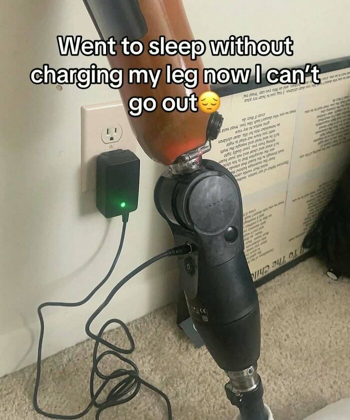 Prosthetic leg plugged into charger with text about not being able to go out, entertaining posts and memes concept.