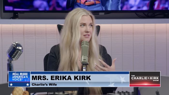 Erika Kirk speaking into a microphone during a podcast recording on the Charlie Kirk Show set with studio equipment visible.