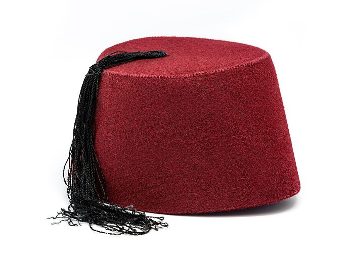 Red fez hat with black tassel isolated on white, representing humorous historical events that sound made up.