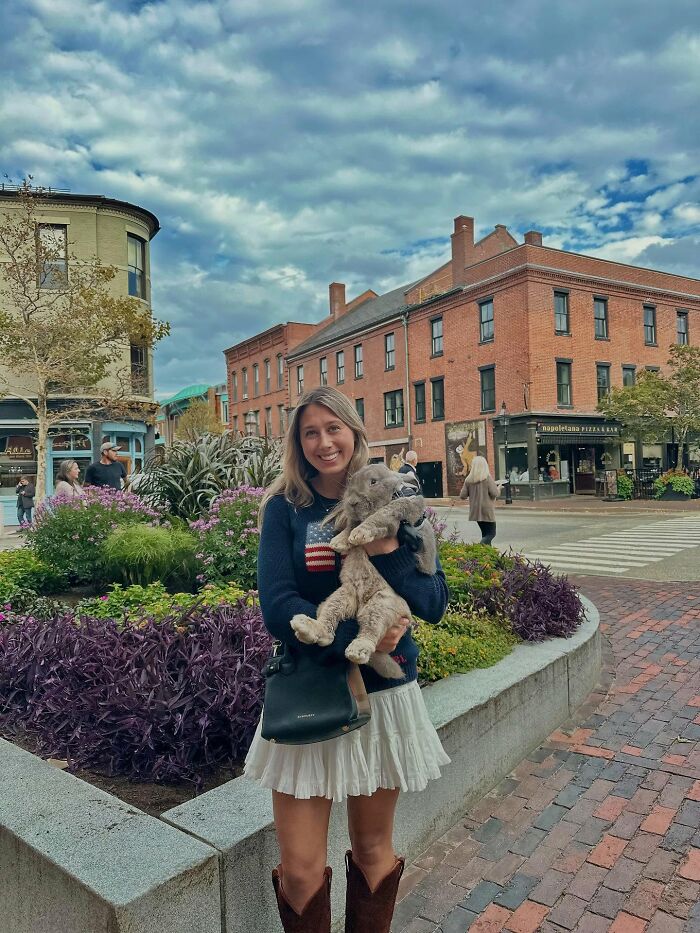 Woman holding a large rabbit outdoors, illustrating Hoppy Gilmore&rsquo;s journey from frail rabbit to affectionate companion.