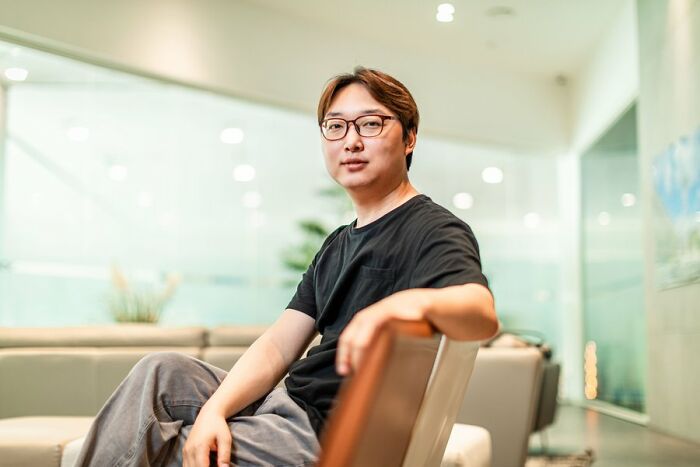 Portrait of South Korea&rsquo;s smartest man sitting casually in a modern room, looking confidently toward the camera.
