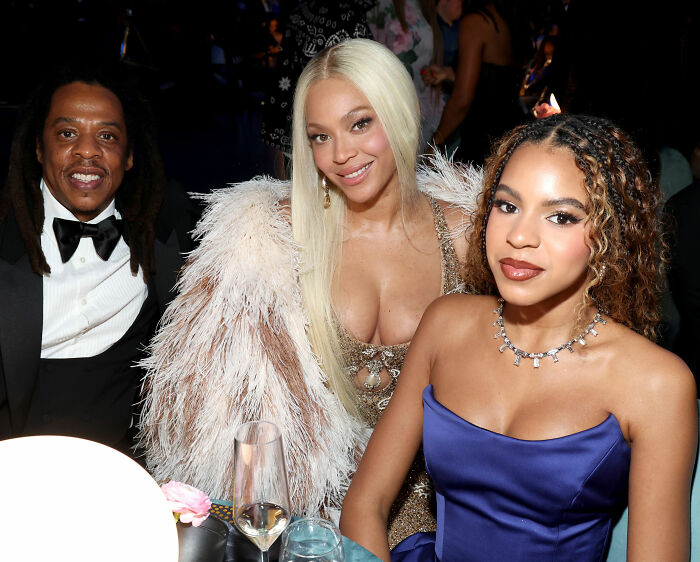 Jay-Z, Beyonc&eacute;, and Blue Ivy posing at event, highlighting celebrity parenting and kids born into fame debates.