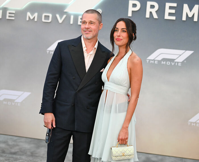 Brad Pitt at Hollywood premiere with a woman, wearing a dark suit, sparking appearance speculation.