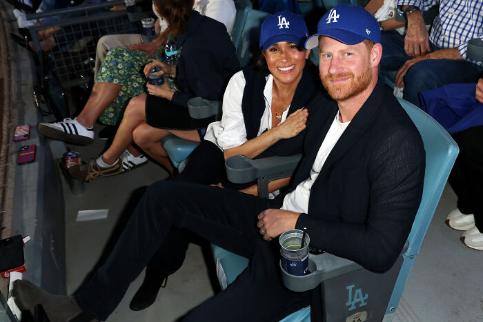 Meghan Markle and Prince Harry attending a Dodgers game, sparking debate over their staged celebration at home.